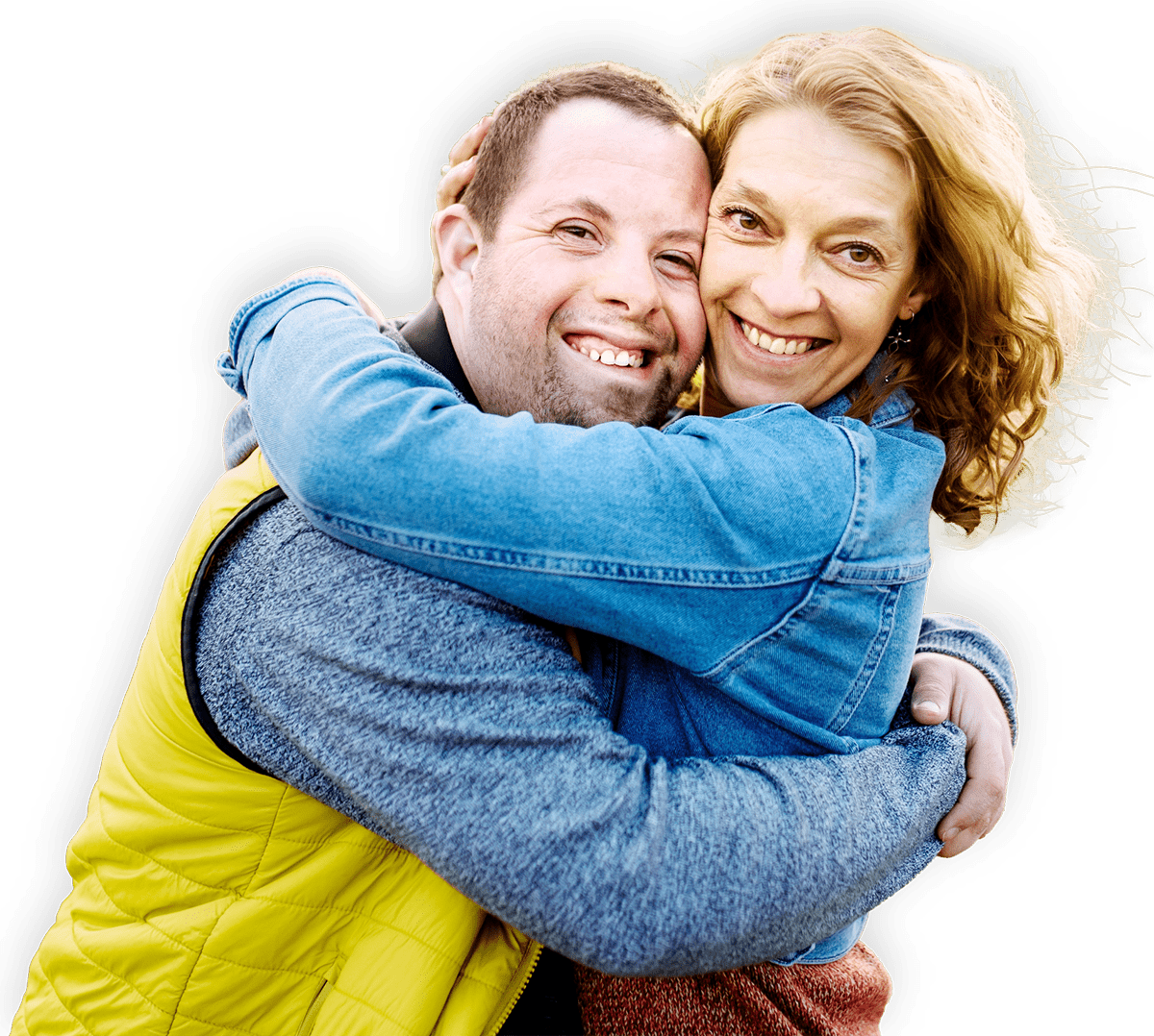 A man with Downs Syndrome hugging a woman and smiling.